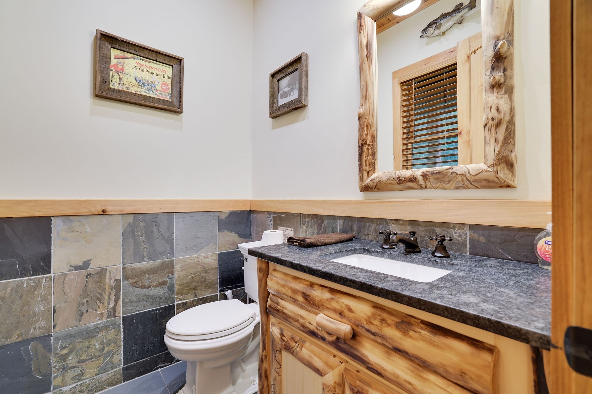 A bathroom with a toilet , sink and mirror.
