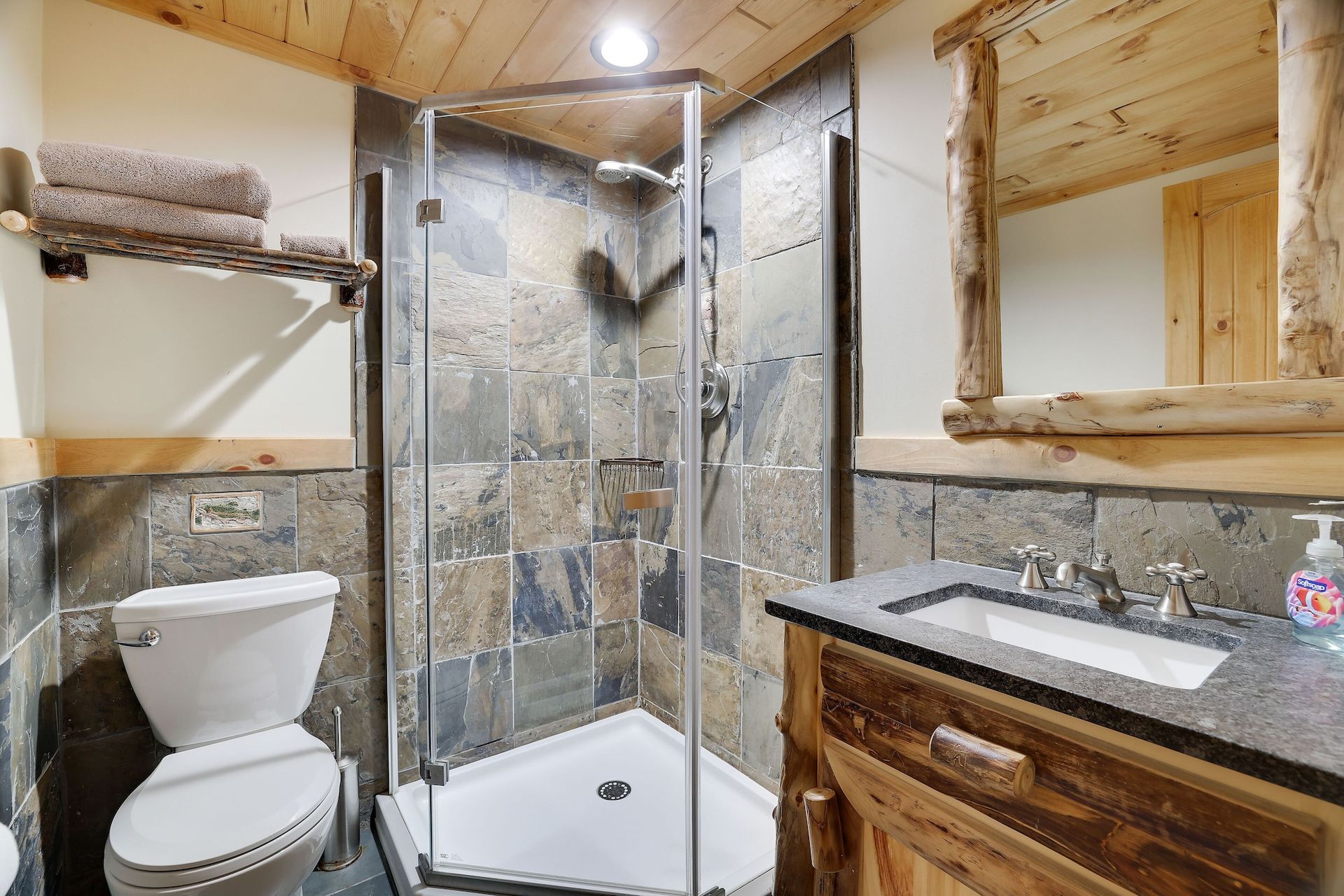 A bathroom with a toilet , sink and shower.