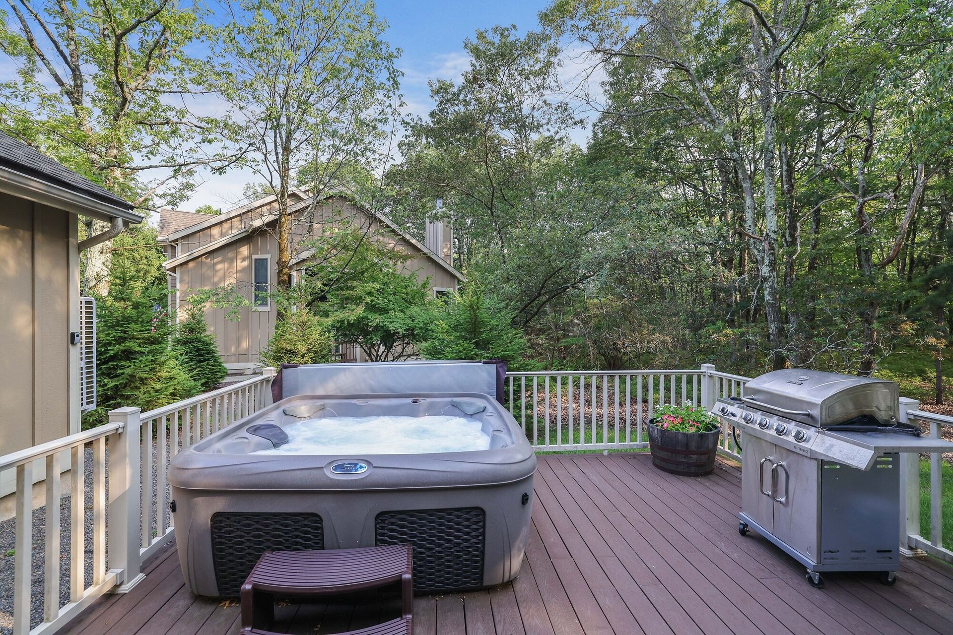 There is a hot tub and a grill on the deck.