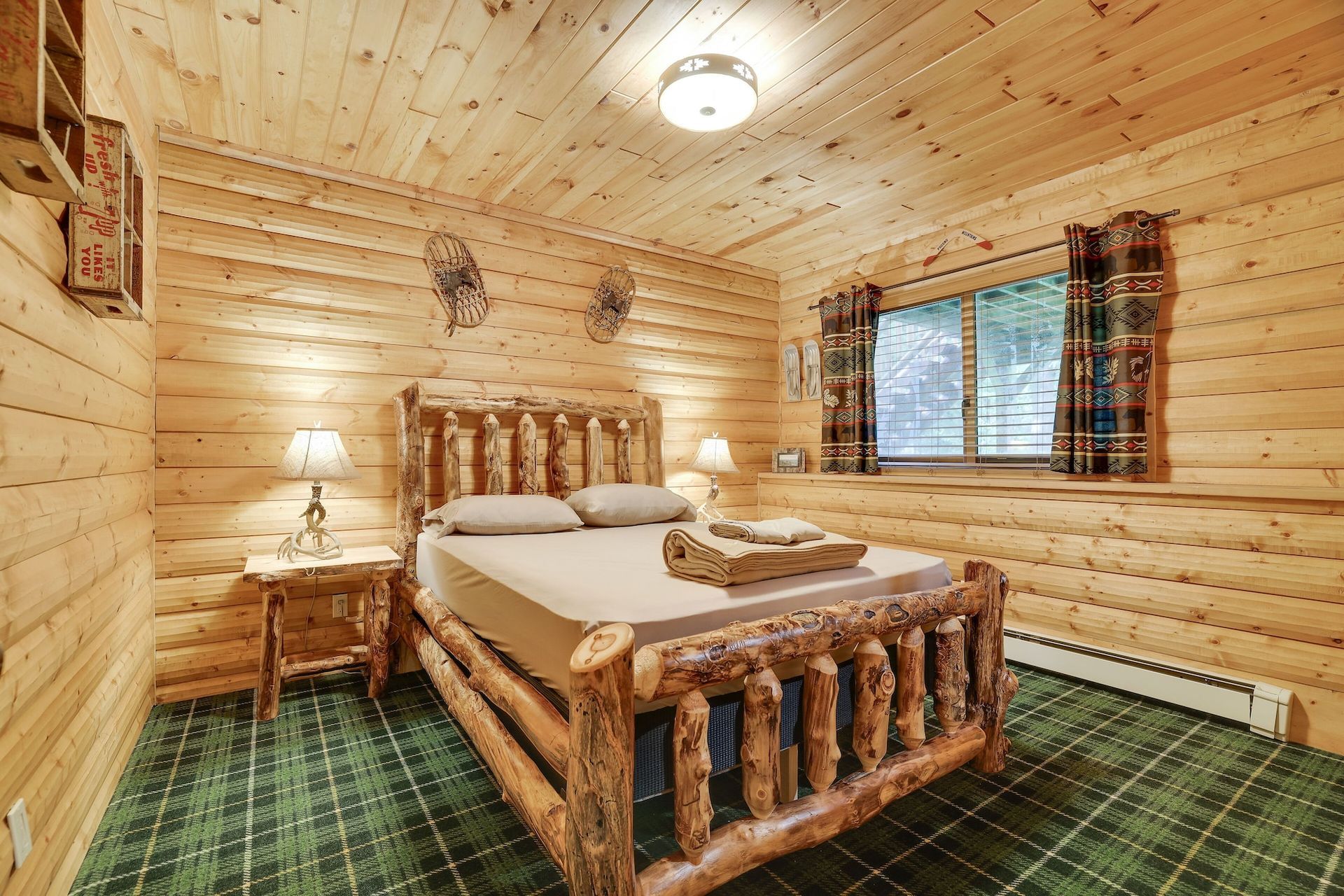 A bedroom in a log cabin with a log bed and a window.