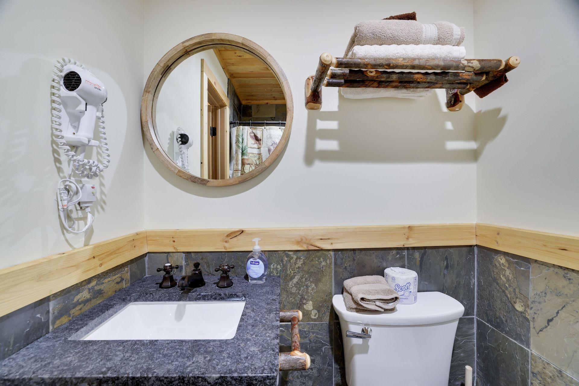 A bathroom with a sink , toilet and mirror.
