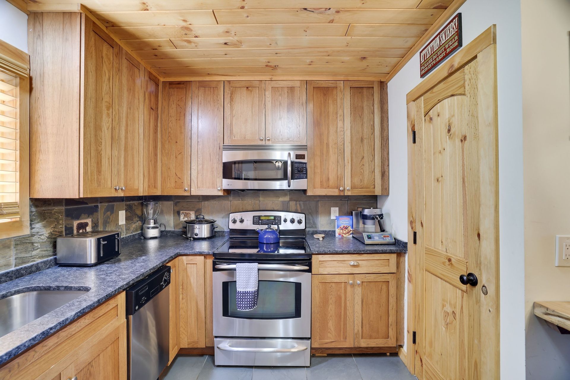 A kitchen with stainless steel appliances and wooden cabinets