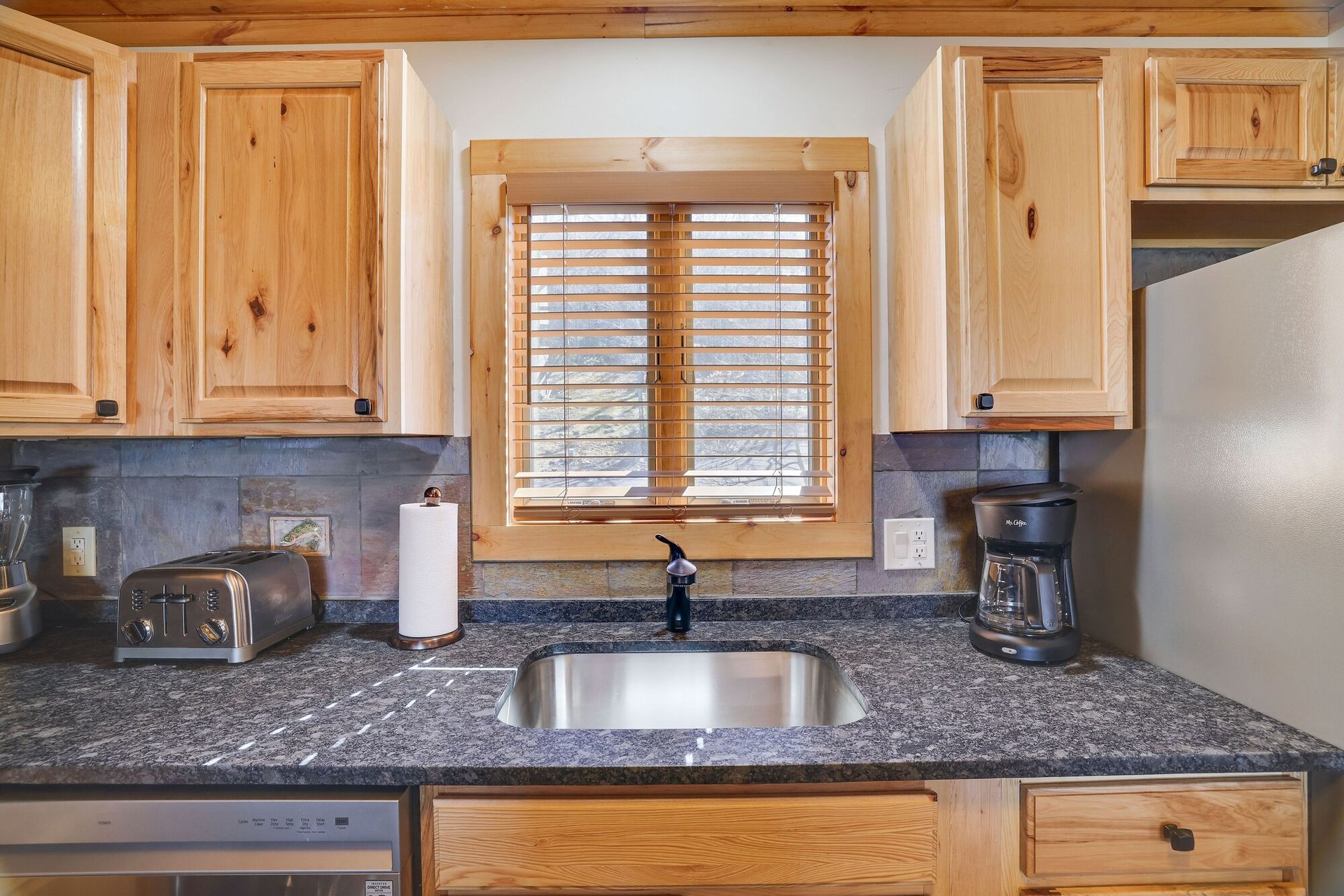 A kitchen with granite counter tops and stainless steel appliances