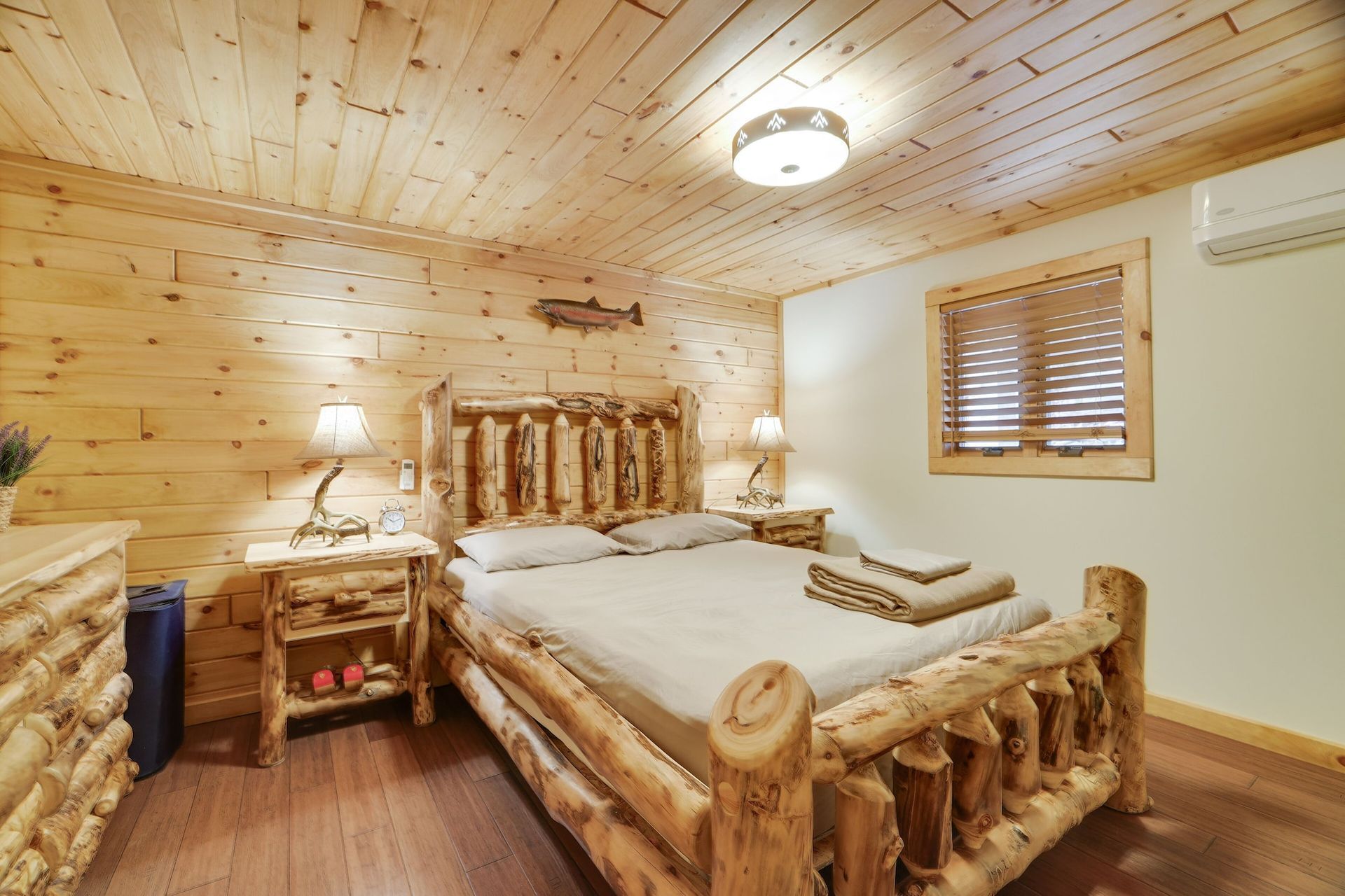 A bedroom with a log bed and two nightstands.