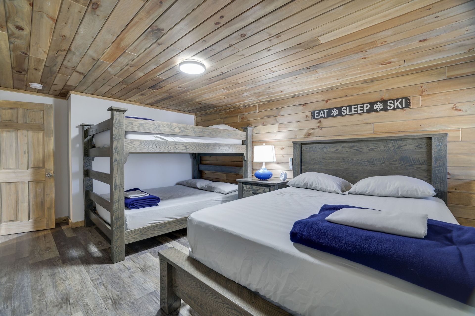 A bedroom with two bunk beds and a large bed.