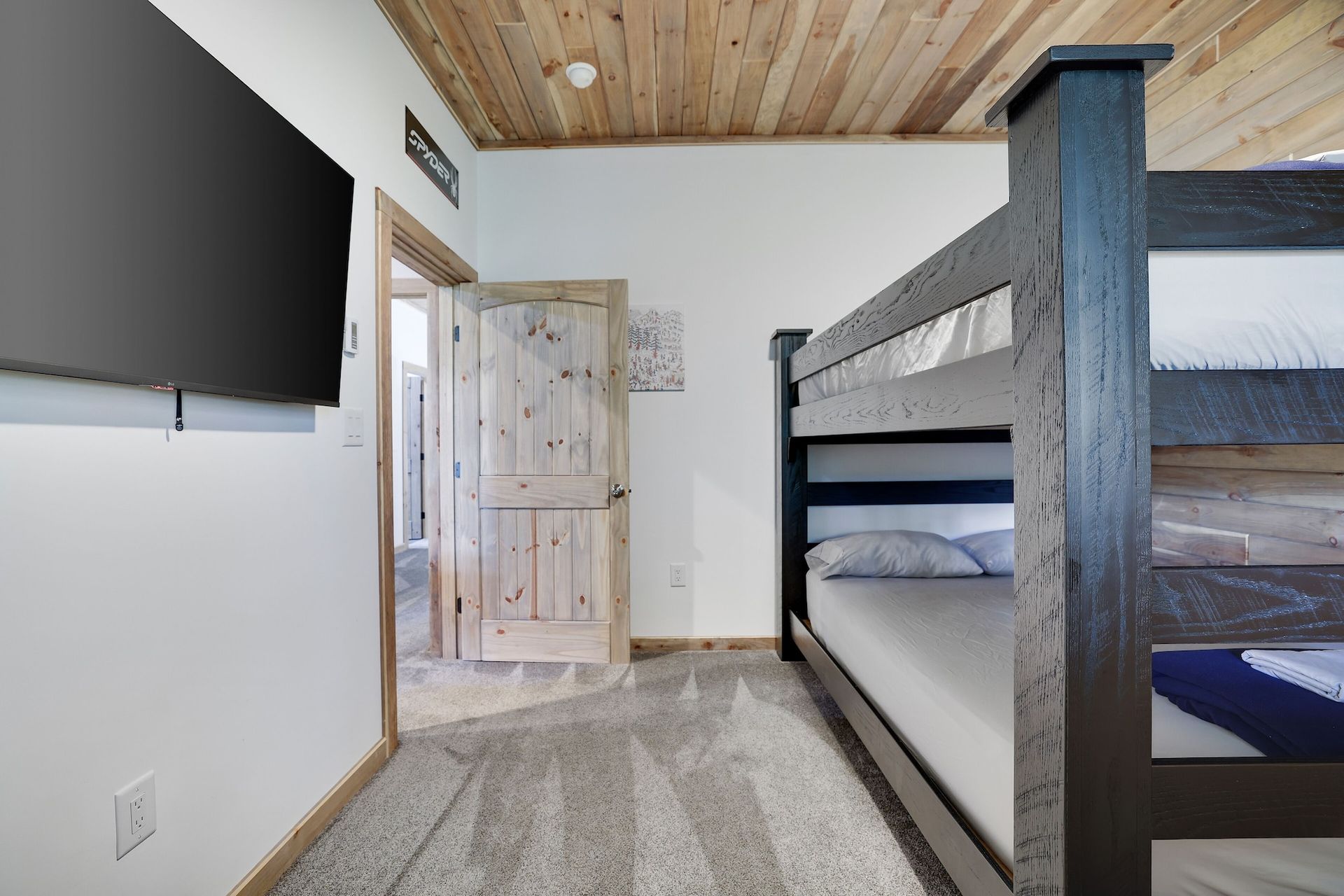 A bedroom with bunk beds and a flat screen tv.