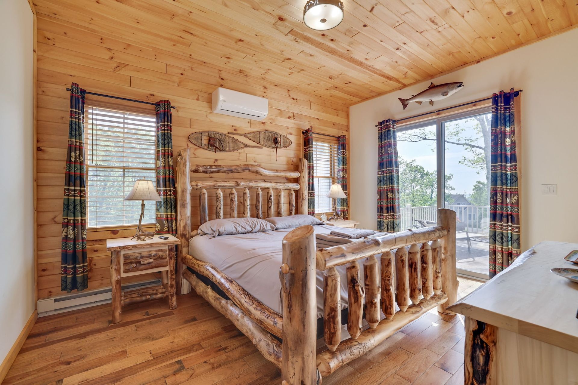 A bedroom with a log bed and a sliding glass door.