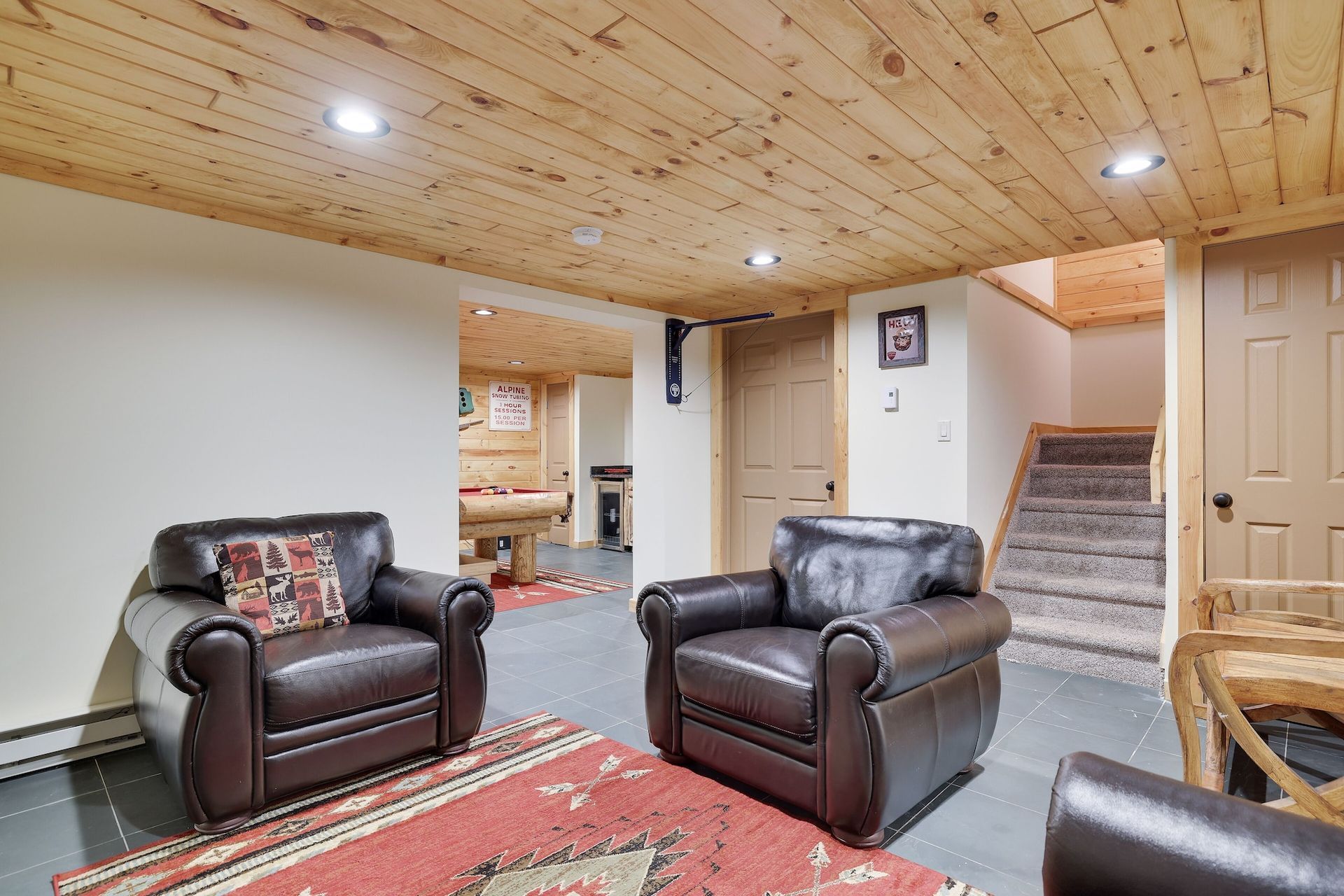 A living room with two leather chairs and a rug.