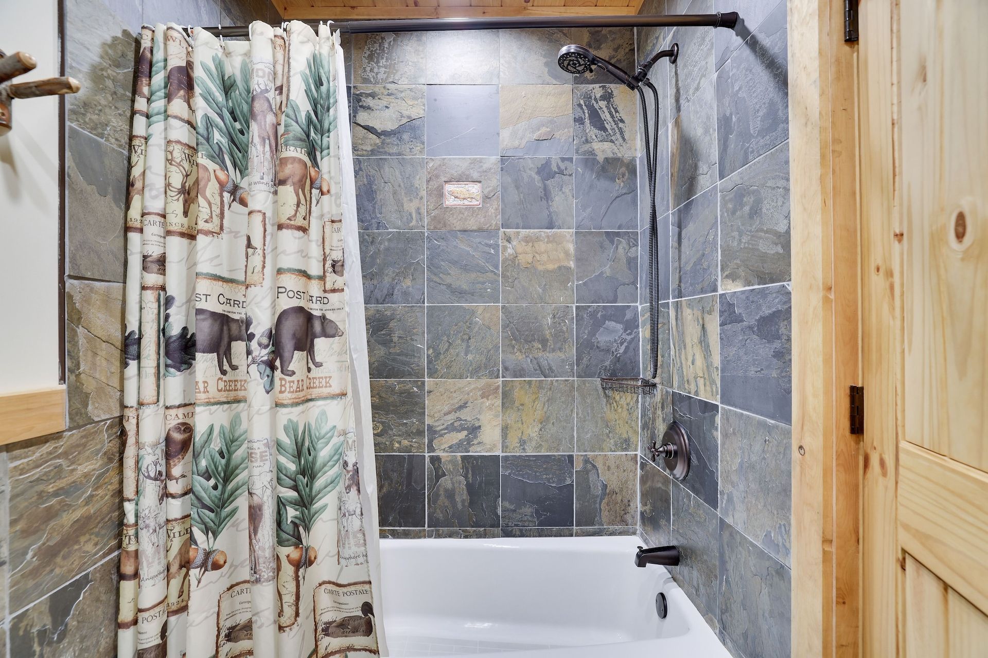 A bathroom with a shower curtain and a bathtub.