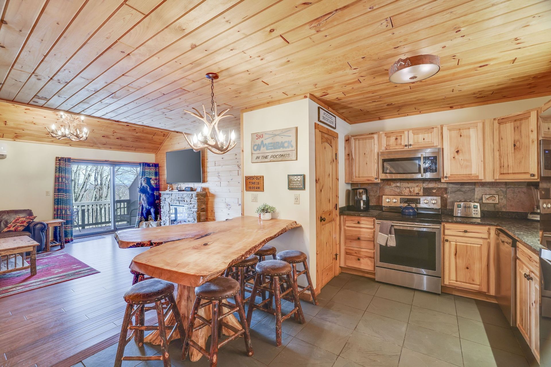 A kitchen with a large wooden table and stools