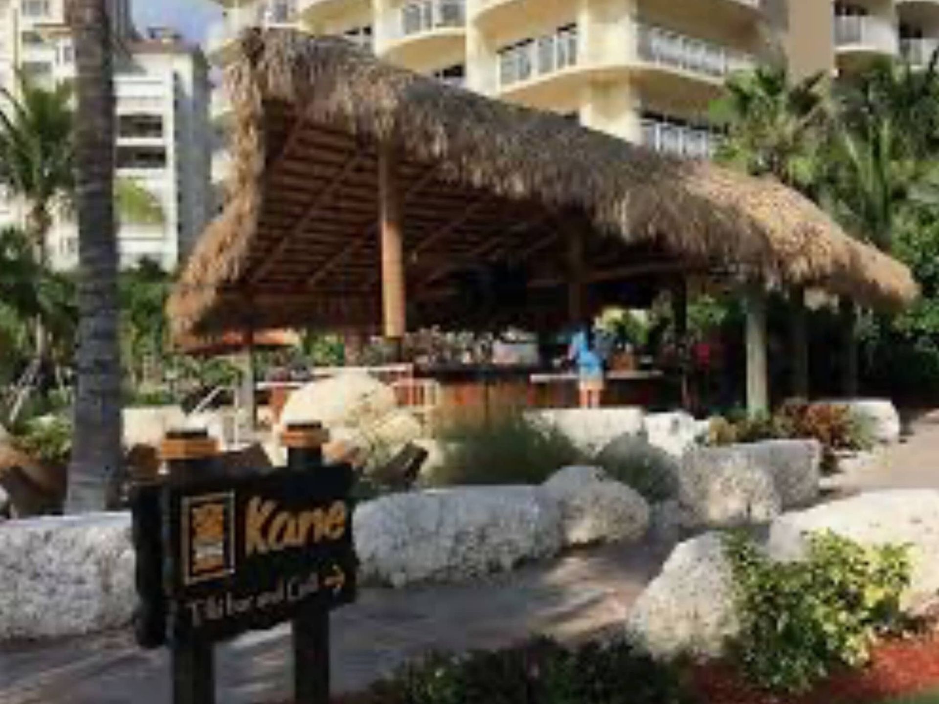 A restaurant with a thatched roof and a sign that says kane