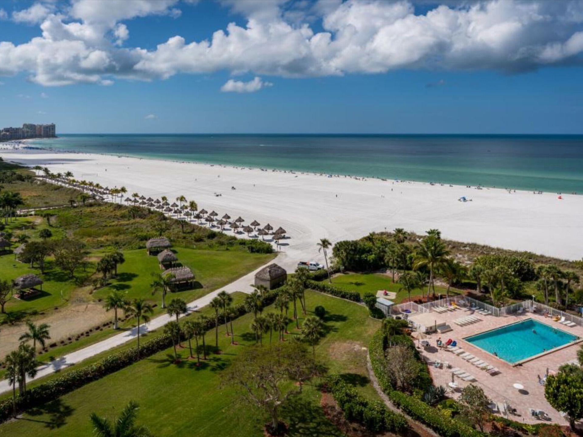 An aerial view of a beach with a swimming pool