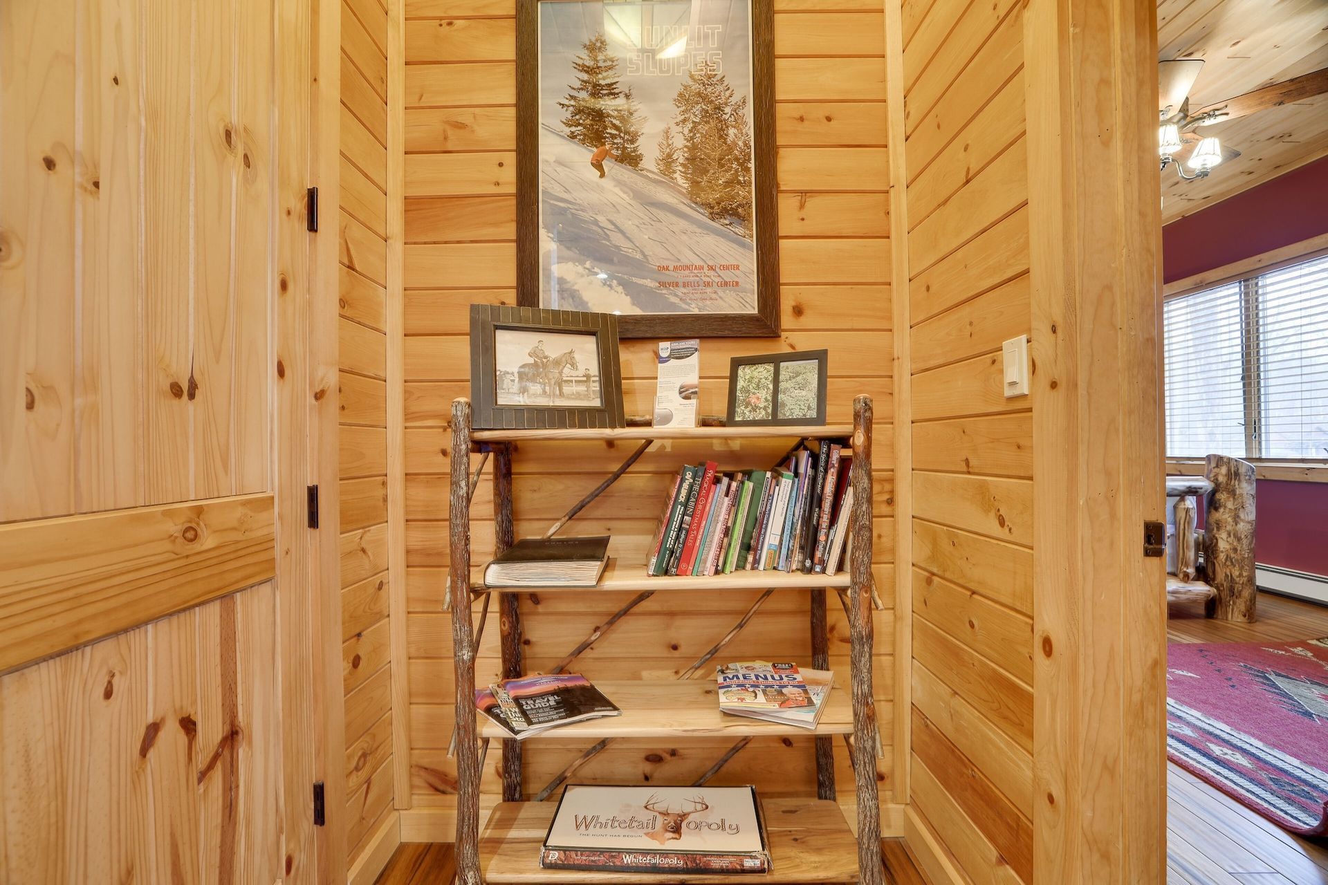 A wooden shelf filled with books and a picture on the wall.