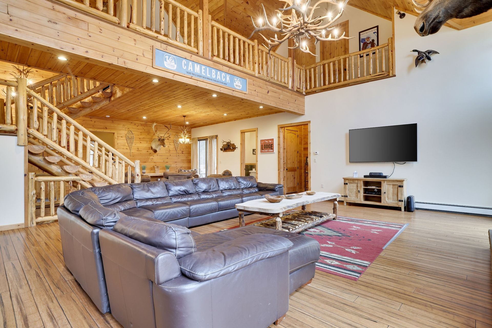 A living room with a large sectional couch and a flat screen tv.