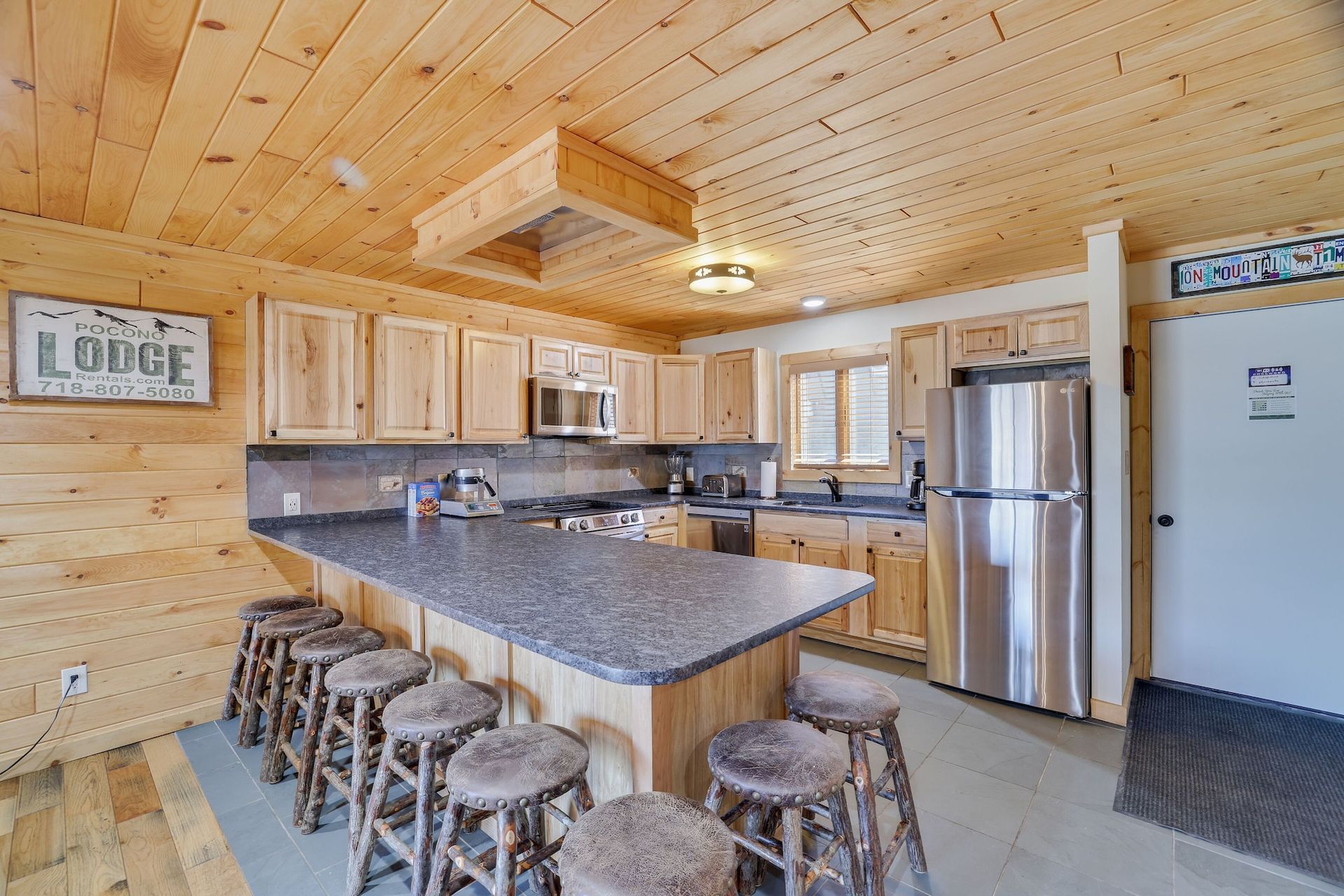 A kitchen in a log cabin with a large island and stools