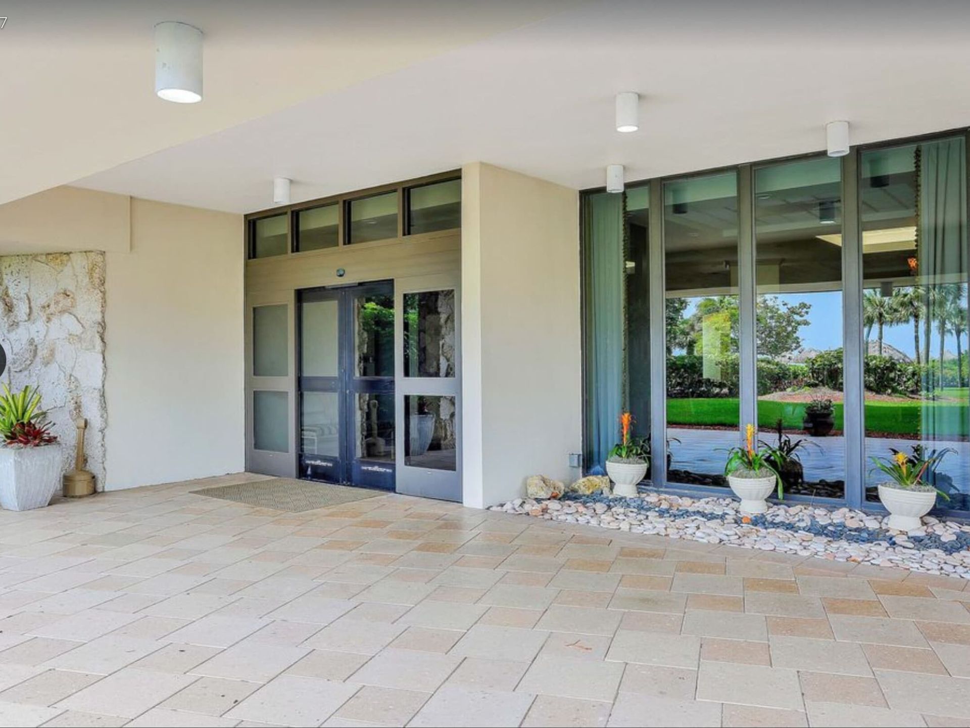 A large building with a lot of windows and potted plants in front of it.