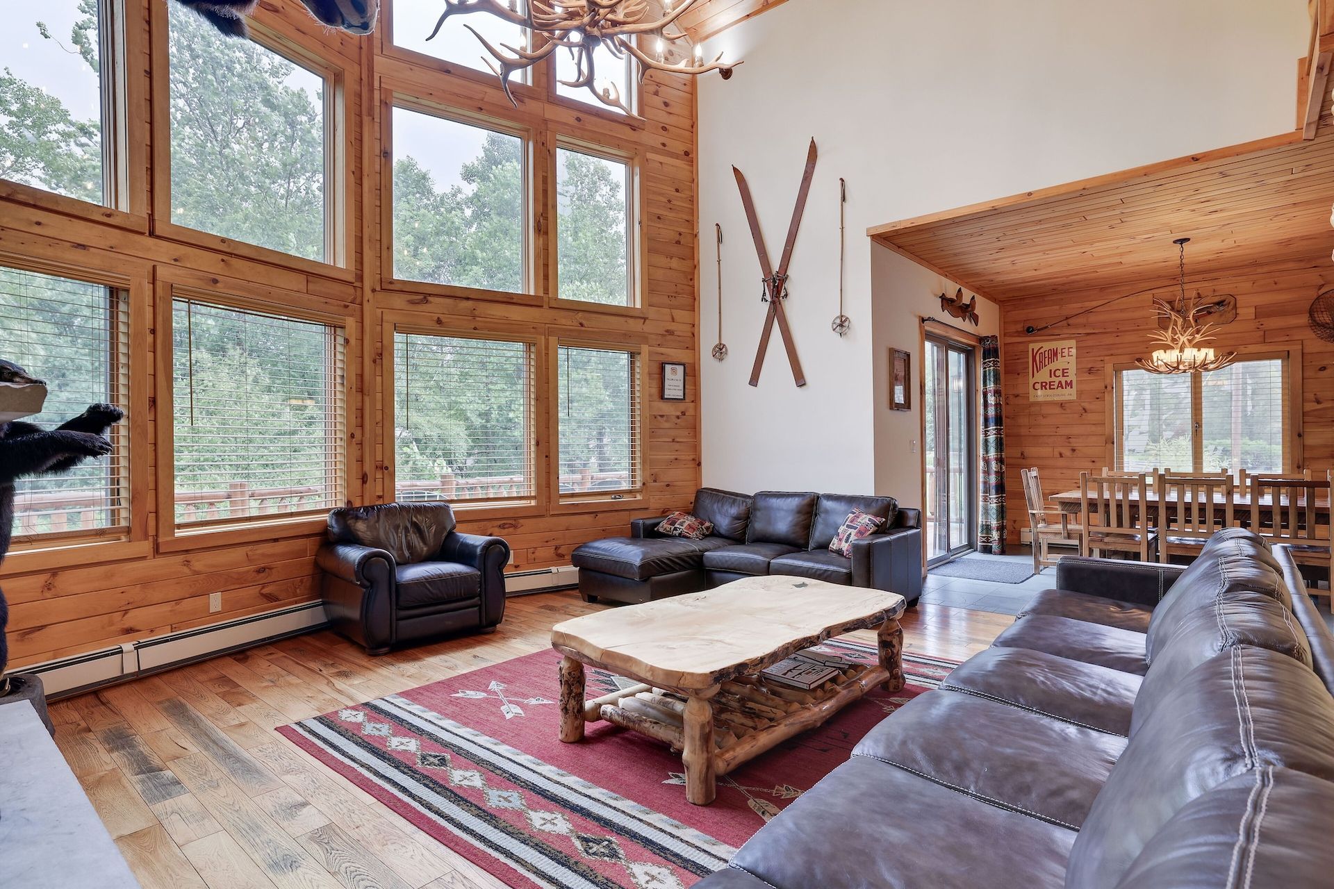 A living room with a couch , chair , coffee table and skis on the wall.