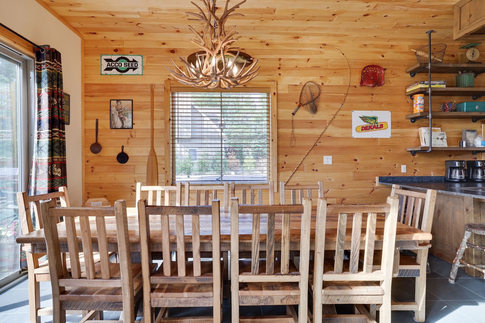 A dining room with a large wooden table and chairs