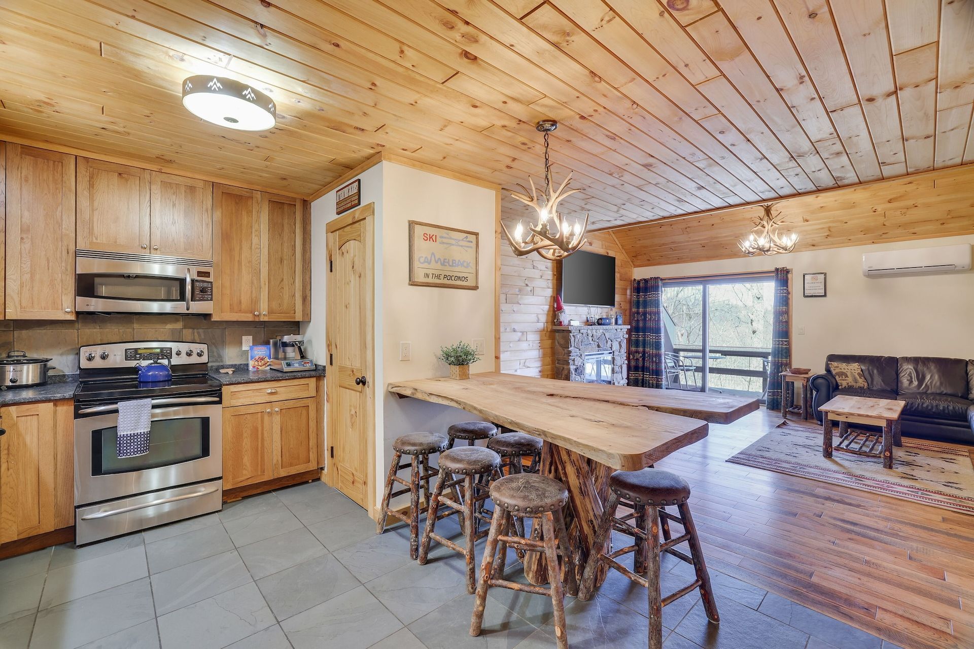 A kitchen with a large wooden table and stools