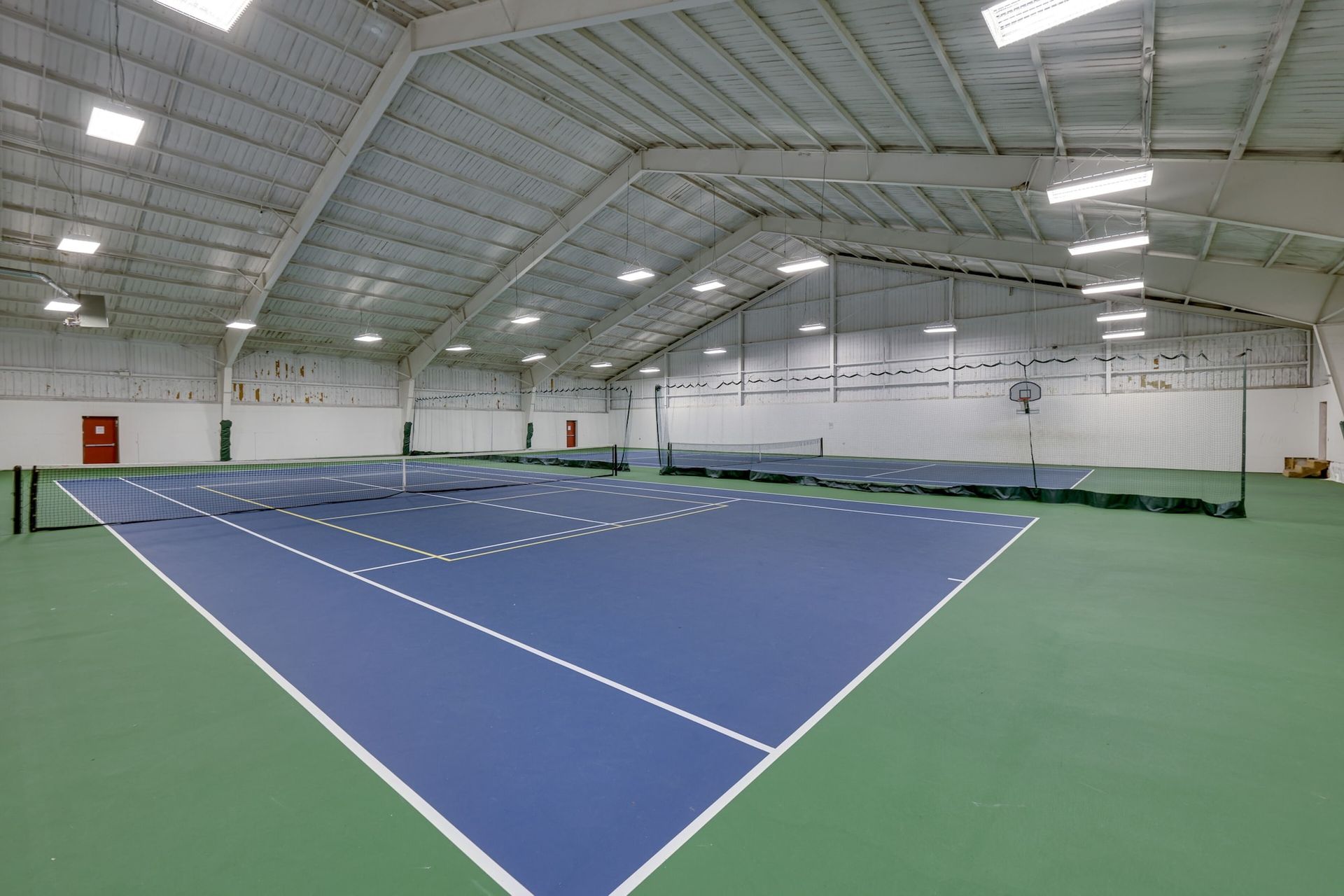 There is a tennis court inside of a building.