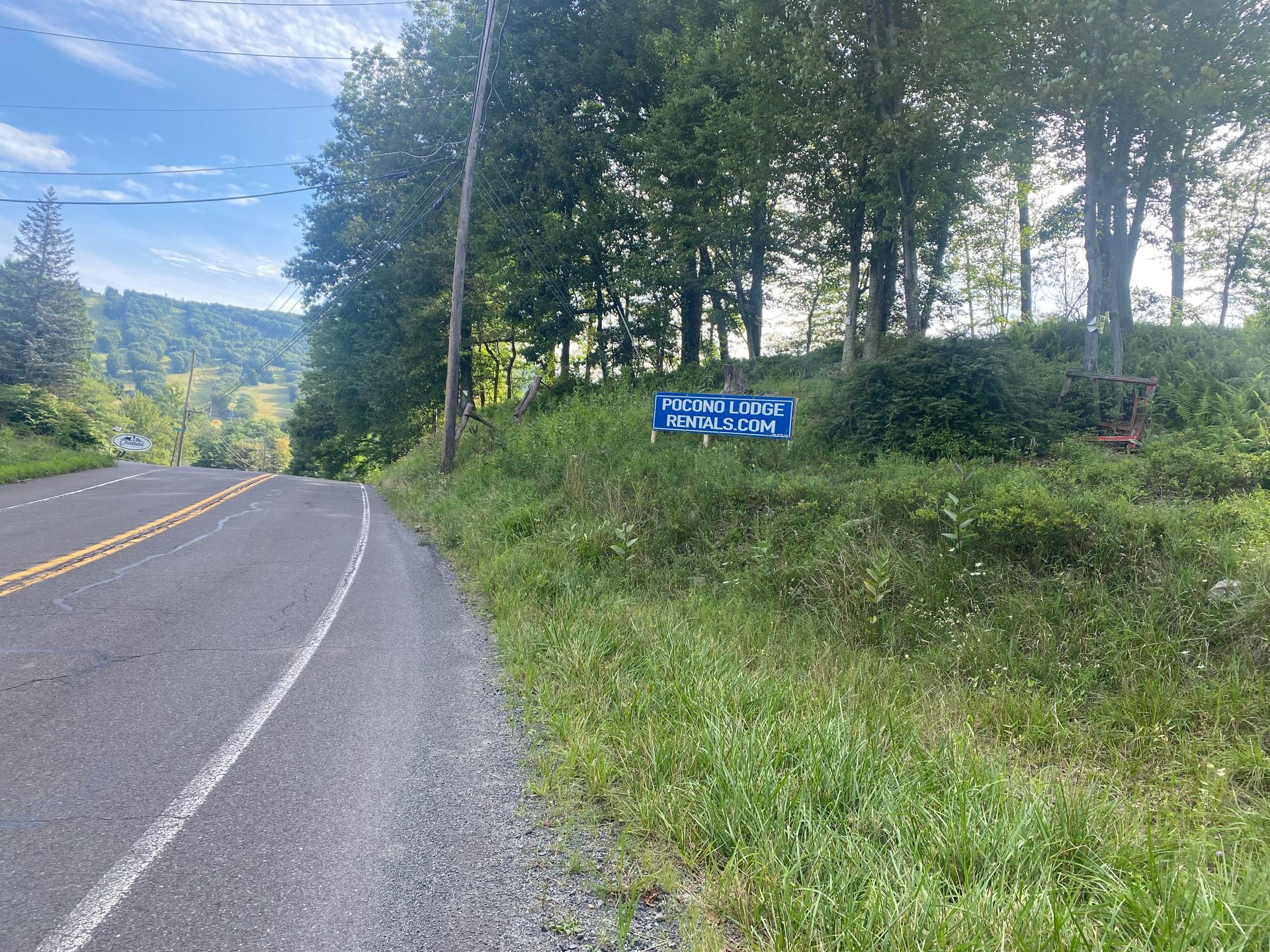 A road with a blue sign on the side of it.