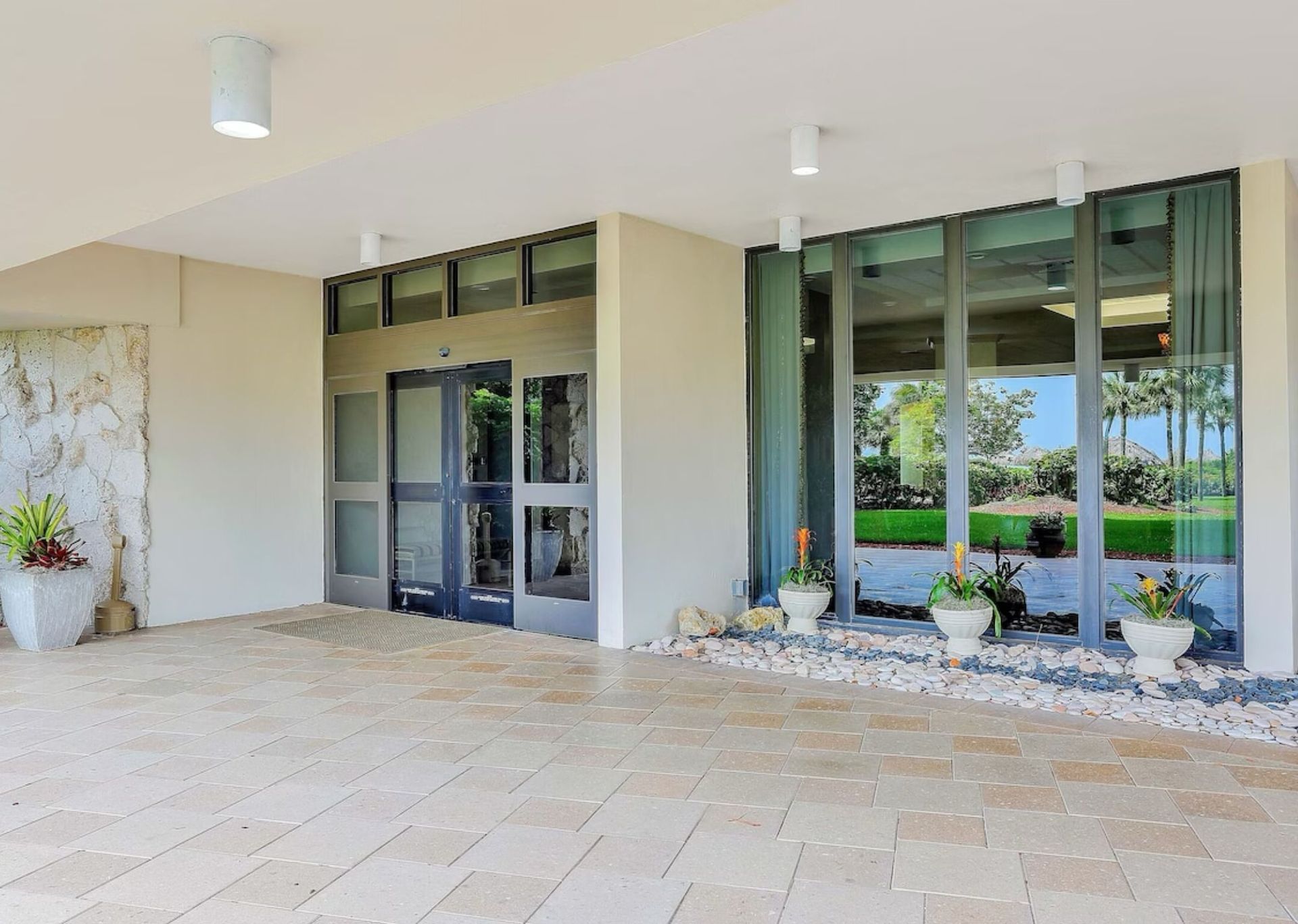 A large building with a lot of windows and potted plants in front of it.