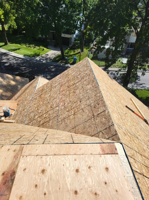 Un toit en forme de pyramide est en cours de construction sur une maison.