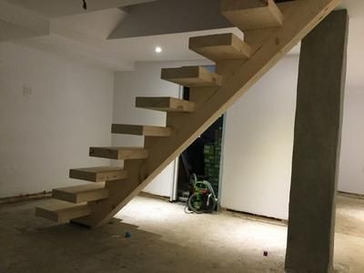 Un escalier en bois est en cours de construction dans une pièce.