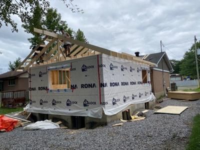 Une maison est en train d'être construite avec un toit qui est en train d'être construit.