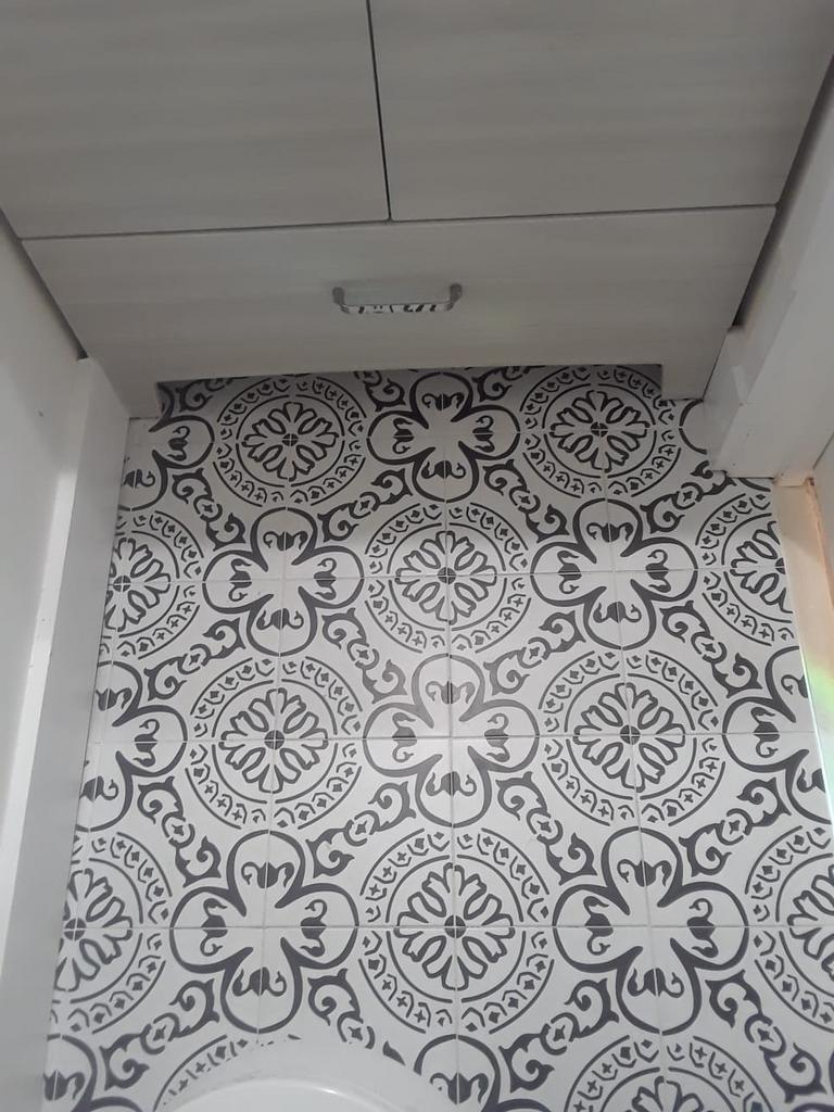 Black and white patterned tile wall with a light fixture on a white ceiling.