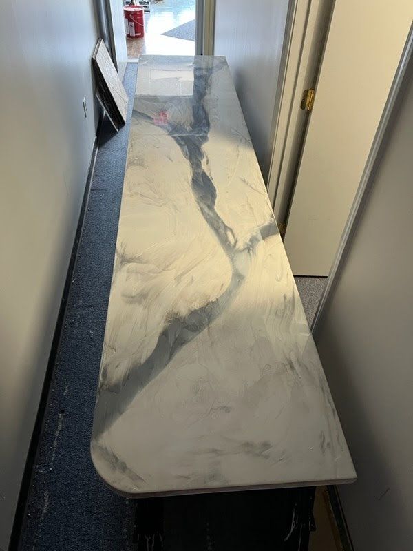 Long, narrow countertop with metallic gray and white epoxy design in a hallway.