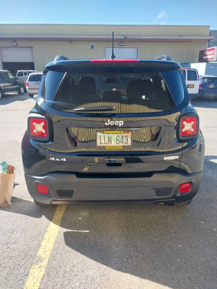 A black Jeep Renegade 4x4 parked in a lot, viewed from the rear, showing a New York license plate LLV 643.