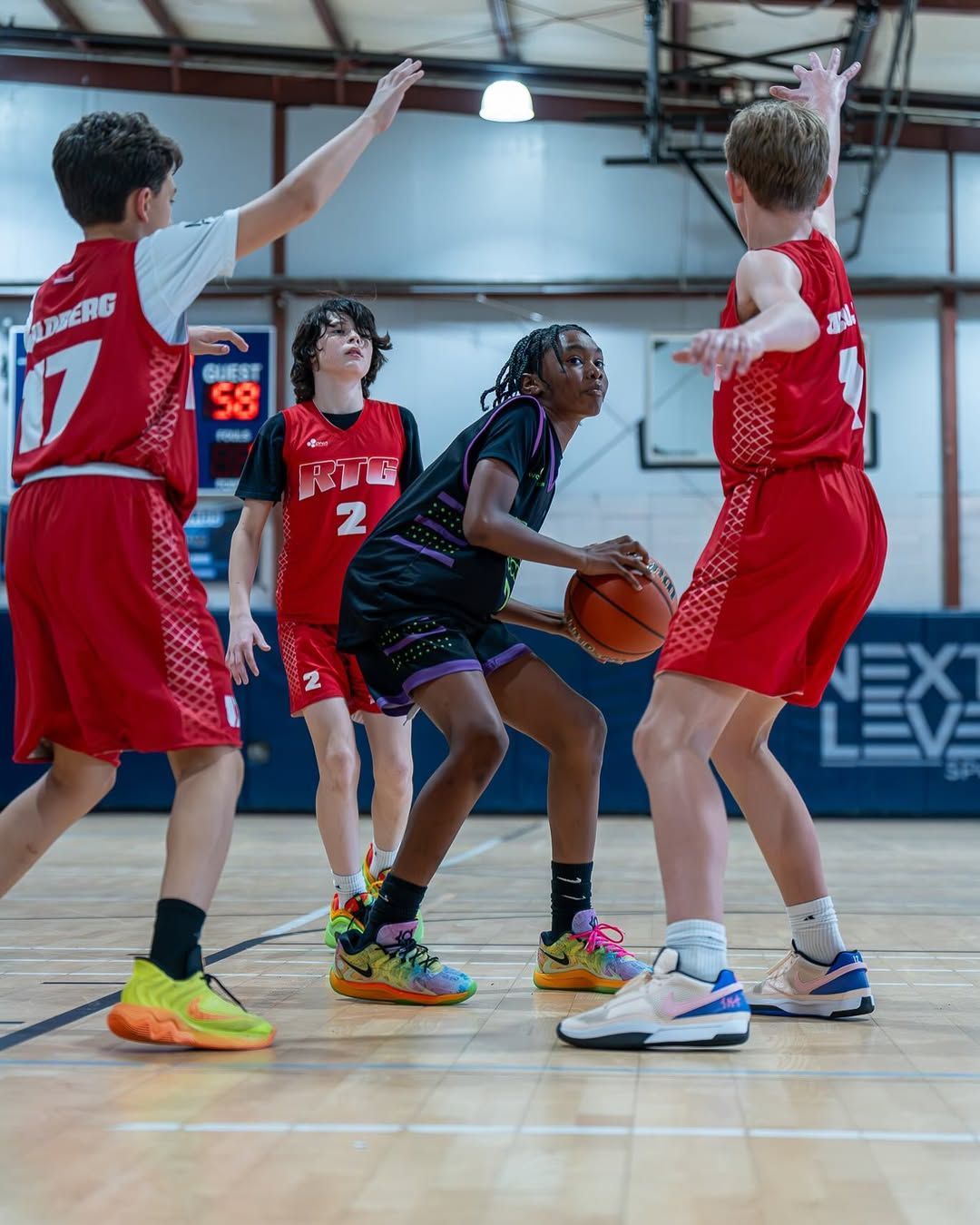 A group of young boys are playing basketball on a court.