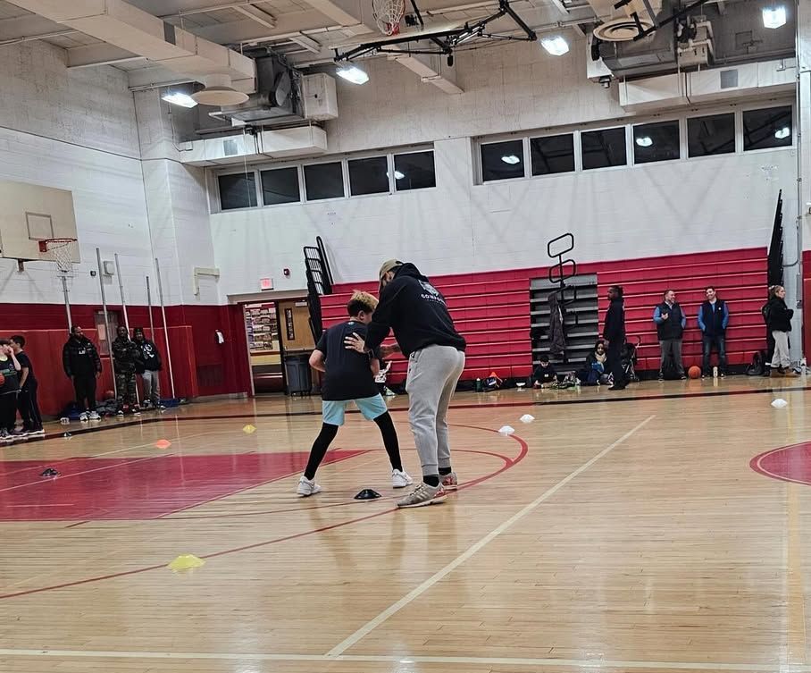 A group of people are playing basketball in a gym.