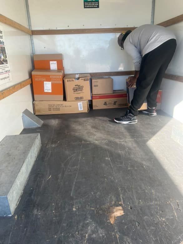 A man is bending over in a truck filled with boxes