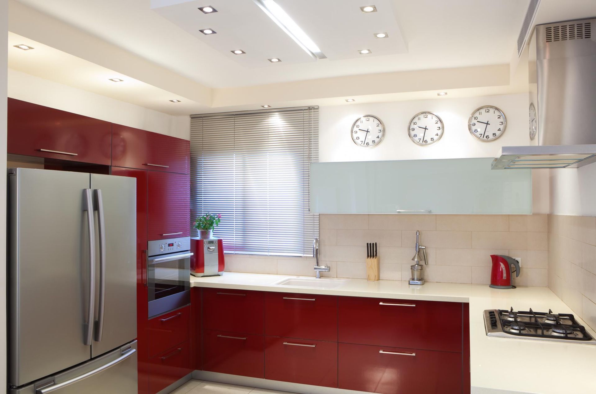 A kitchen with red cabinets and stainless steel appliances