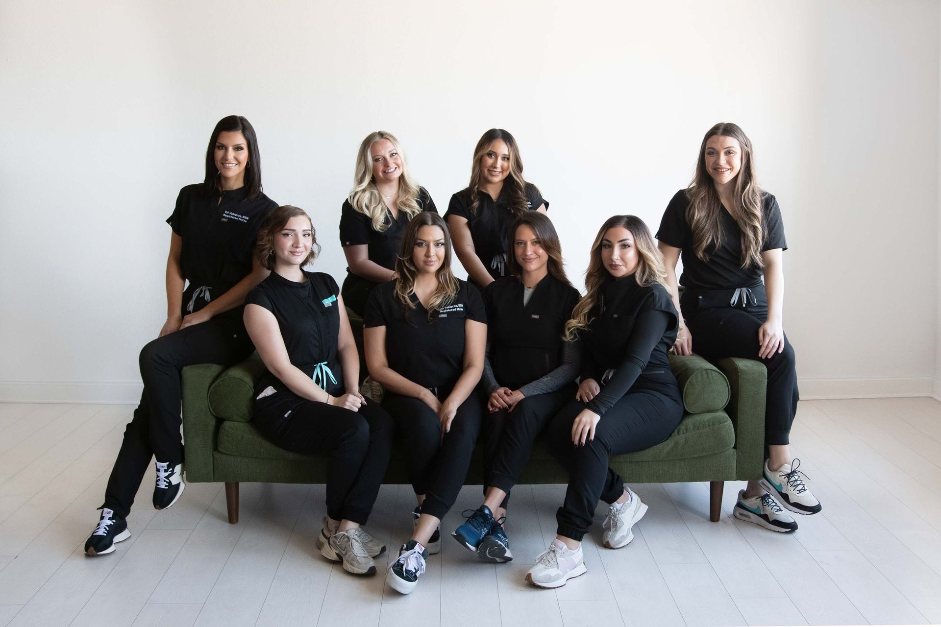 A group of women in black scrubs are posing for a picture