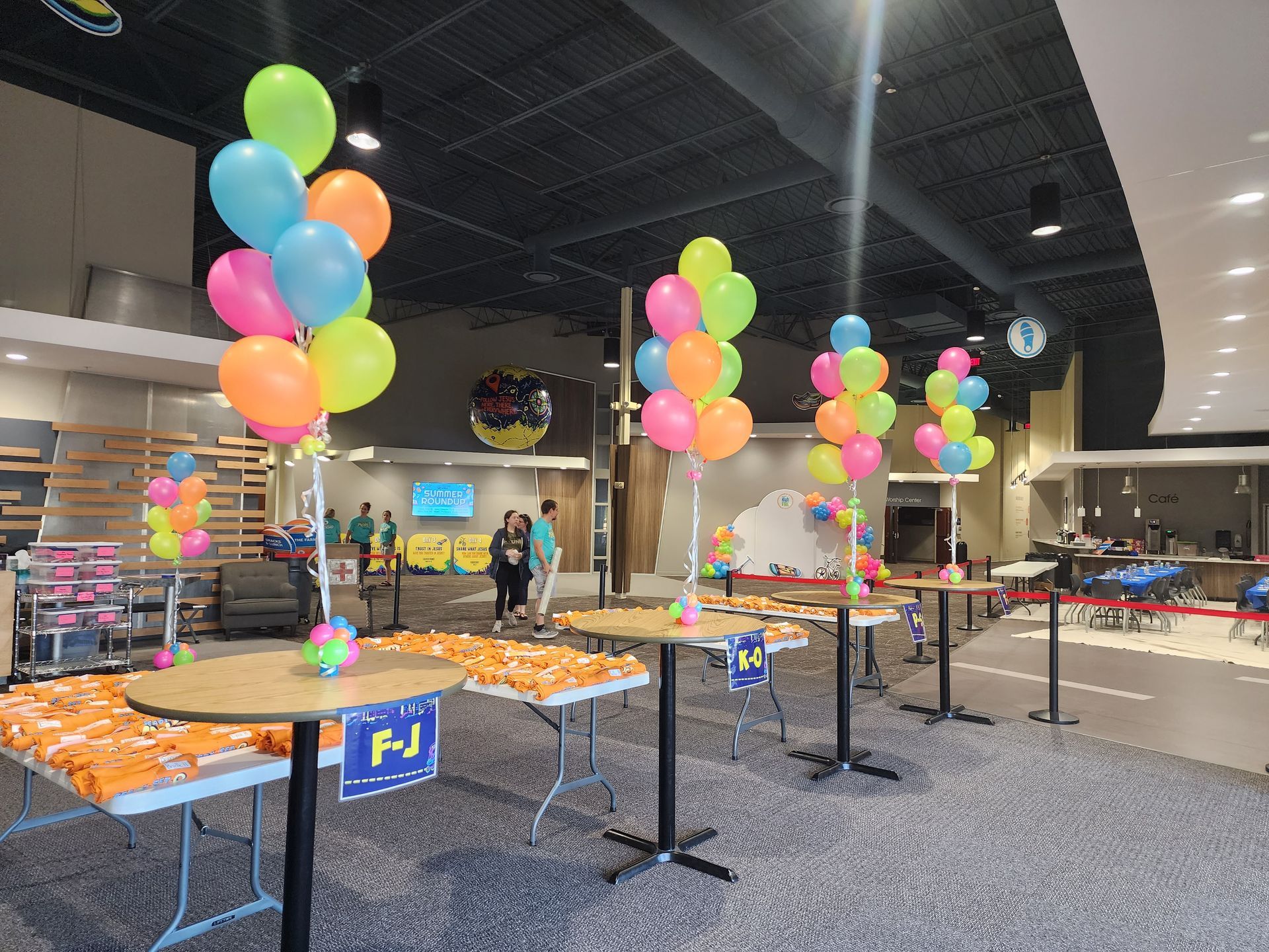 A room filled with tables and balloons for a party.