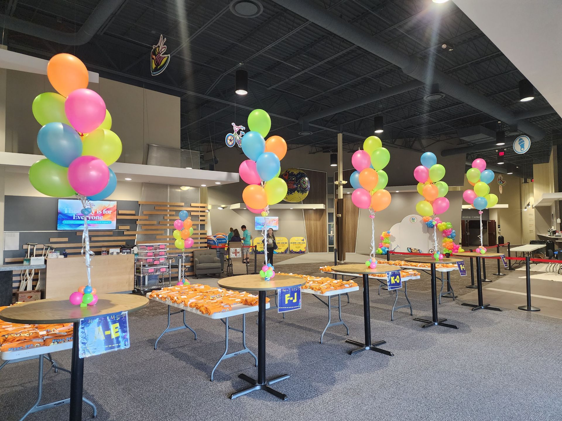 A room filled with tables and balloons for a party