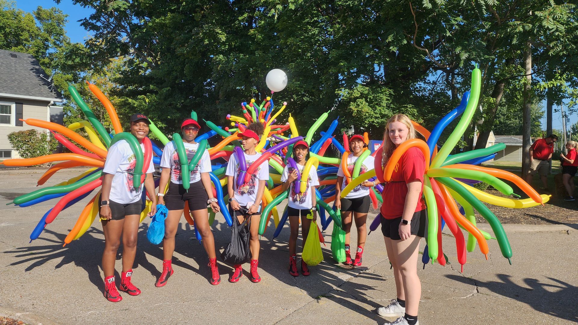 A car dealership is decorated with red and white balloons