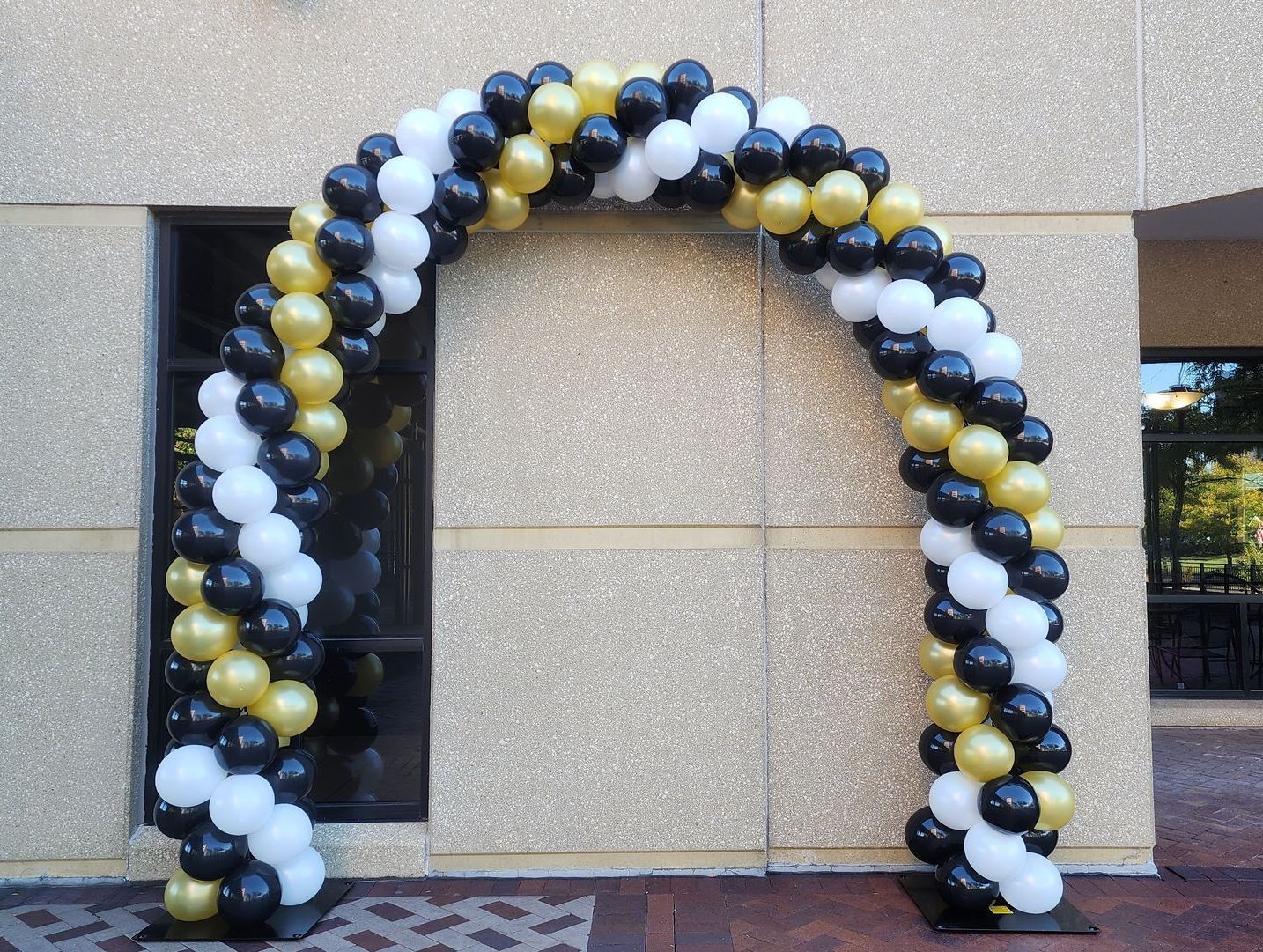 A blue balloon arch with gold stars on a white wall.