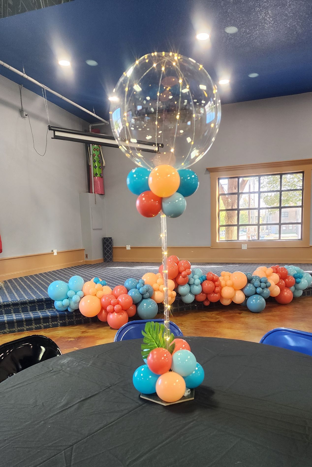 A balloon centerpiece is sitting on a table in a room.