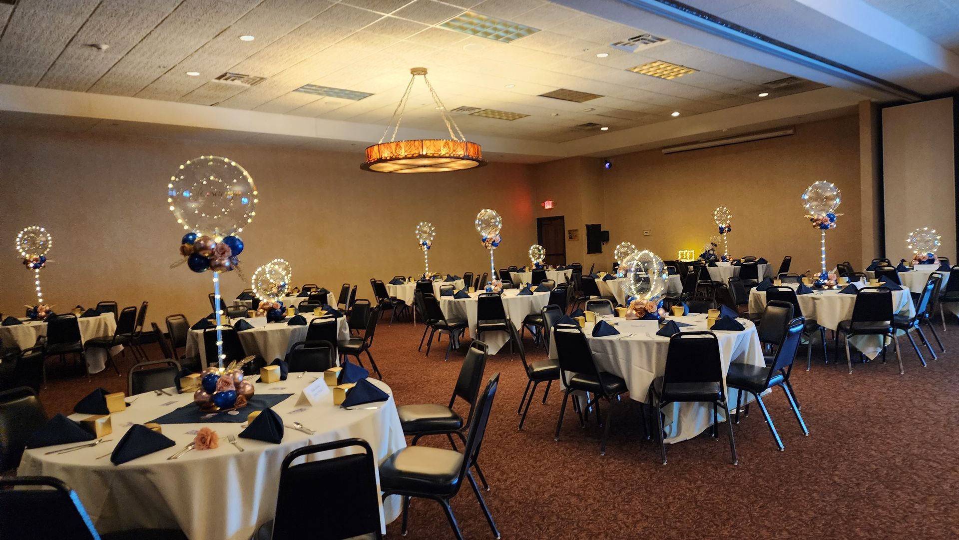 A large room with tables and chairs set up for a party