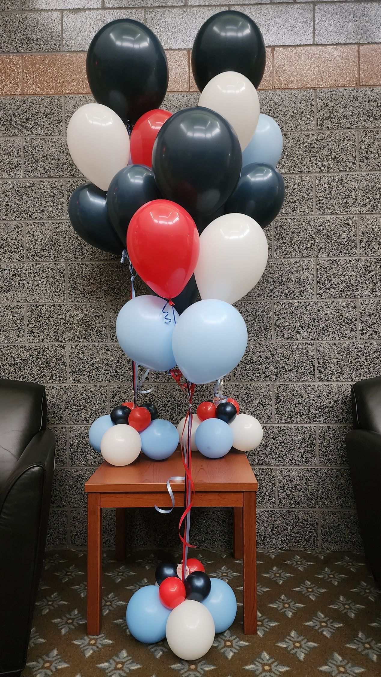 A bunch of balloons are sitting on top of a wooden table.