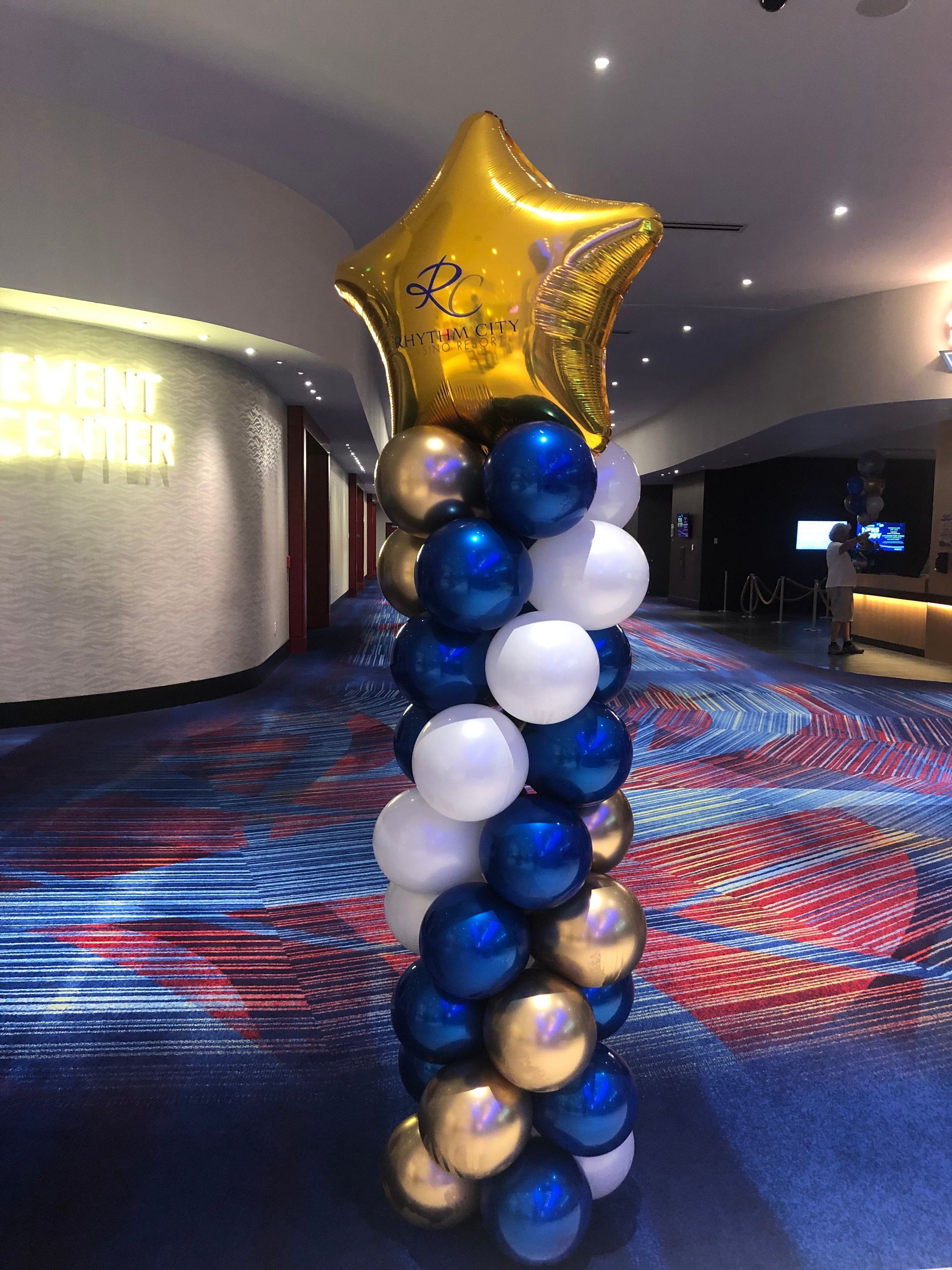 A column of blue and gold balloons with a star shaped balloon in the middle