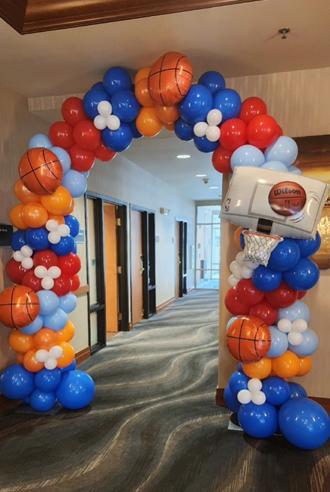 A blue and white balloon arch is in front of a building.