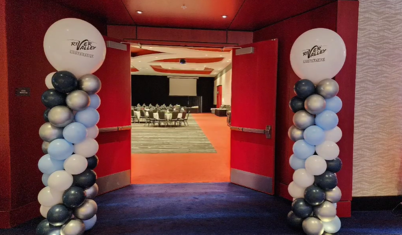 Two columns of balloons are lined up in a hallway leading to a conference room.