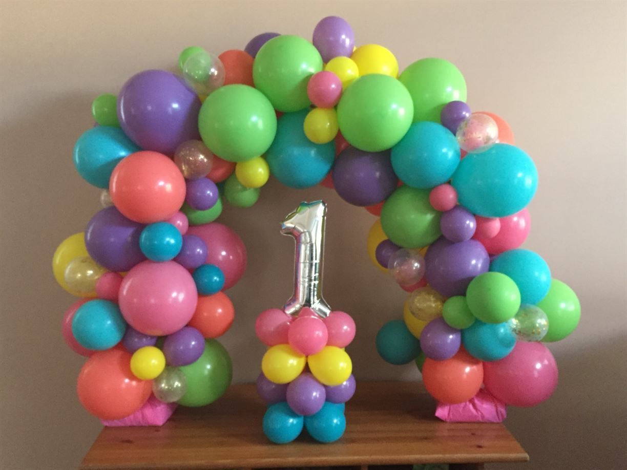 A bunch of colorful balloons are sitting on a table.