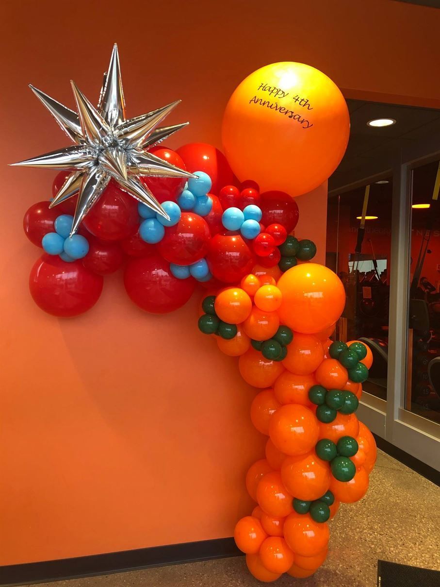 A bunch of orange and red balloons with one that says happy 50th anniversary