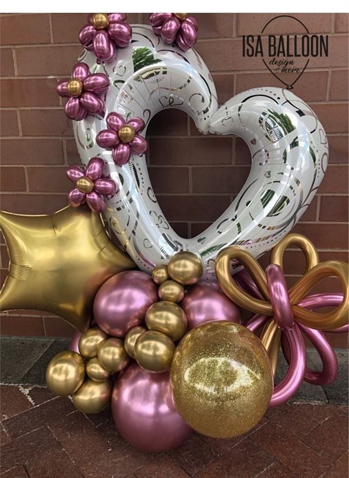 A bunch of balloons are sitting on a table in front of a brick wall.